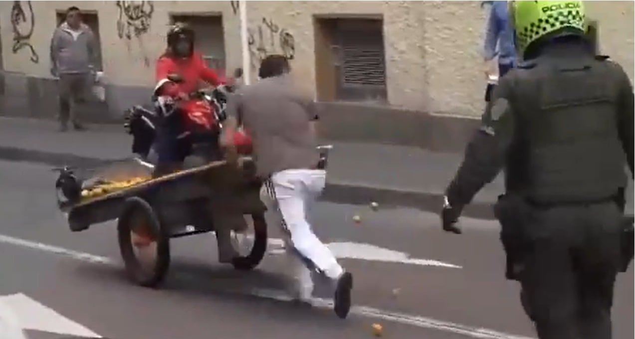 Vendedor ambulante huye del lugar con su carretilla.