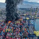 This handout photograph taken and released by Turkish agency DHA (Demiroren News Agency) shows smoke rising from burning containers at the harbor of Iskenderun in Hatay, a day after a 7.8-magnitude earthquake struck the country's southeast, on February 7, 2023. - Rescuers in Turkey and Syria braved frigid weather, aftershocks and collapsing buildings, as they dug for survivors buried by an earthquake that killed more than 5,000 people. Some of the heaviest devastation occurred near the quake's epicentre between Kahramanmaras and Gaziantep, a city of two million where entire blocks now lie in ruins under gathering snow. (Photo by Handout / DHA (Demiroren News Agency) / AFP) / - Turkey OUT / RESTRICTED TO EDITORIAL USE - MANDATORY CREDIT "AFP PHOTO / DHA (Demiroren News Agency) " - NO MARKETING NO ADVERTISING CAMPAIGNS - DISTRIBUTED AS A SERVICE TO CLIENTS