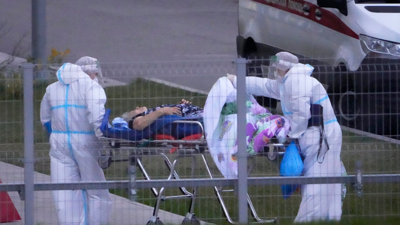 Trabajadores médicos trasladan a un posible paciente de coronavirus en un hospital en Kommunarka, a las afueras de Moscú, Rusia.