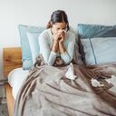 Woman with flu in bed, she use home medicine to handle sickness