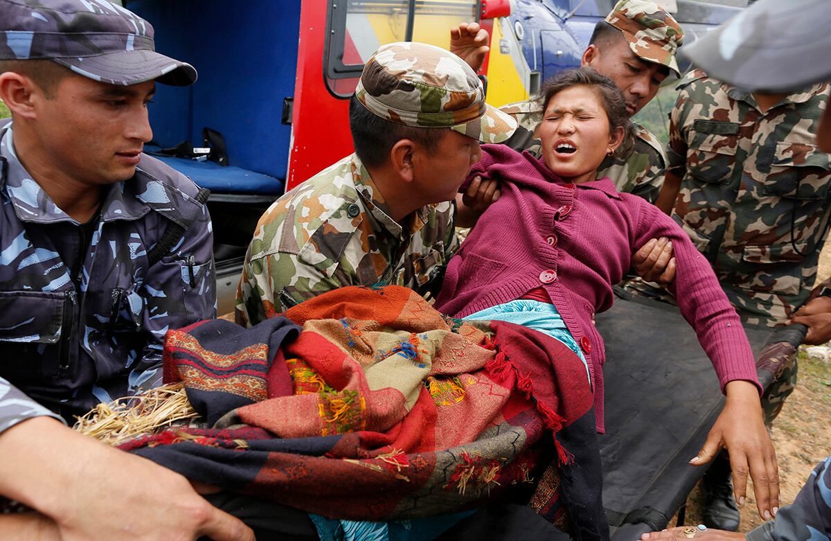 Sita Karka sufrió una fractura doble en sus piernas tras el terremoto en Nepal y llega a una zona de aterrizaje de helicópteros en el distrito de Gorkha, Nepal. (AP)