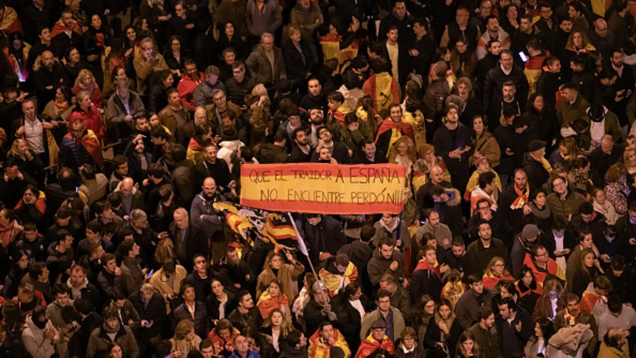 Se ve a manifestantes sosteniendo una bandera española con el mensaje "que el traidor a España no encuentre perdón" durante una protesta frente a la sede del partido socialista PSOE en la calle Ferraz por séptimo día consecutivo de protestas tras el reciente acuerdo entre PSOE y Junts, desarrollado hoy en Bruselas. (Foto de Marcos del Mazo/LightRocket vía Getty Images)
