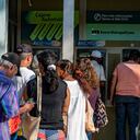 Varias personas hacen fila para retirar dinero de cajeros automáticos en un banco de La Habana el 3 de agosto de 2023.
