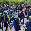 Colombian indigenous people taking part in a "Minga" (indigenous meeting) walk along the Pan-American highway as they arrive in the city of Cali with the expectation of meeting President Ivan Duque, on October 12, 2020. - Thousands of indigenous people arrived in Cali where they hope to meet with President Duque, after having summoned him through a letter in recent days, in which they express concern about the increase of violence due to the presence of armed groups in their territories, the murder of indigenous and social leaders, and the recent massacres. (Photo by Luis ROBAYO / AFP)