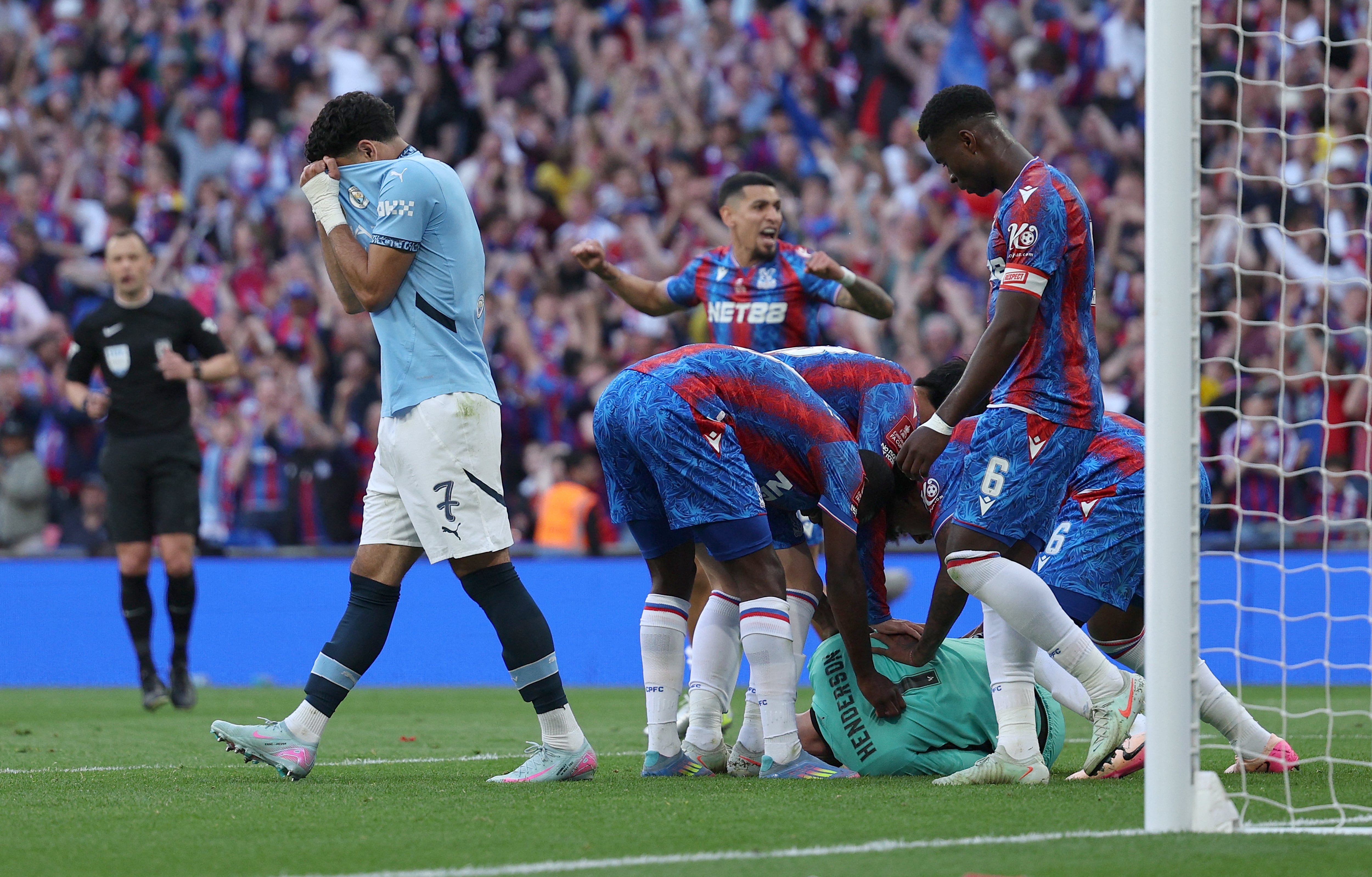 Manchester City's Egyptian striker #07 Omar Marmoush reacts as Crystal Palace's English goalkeeper #01 Dean Henderson is mobbed by teammates after saving a penalty during the English FA Cup final football match between Crystal Palace and Manchester City at Wembley stadium in London, on May 17, 2025. (Photo by Adrian Dennis / AFP) / NOT FOR MARKETING OR ADVERTISING USE / RESTRICTED TO EDITORIAL USE