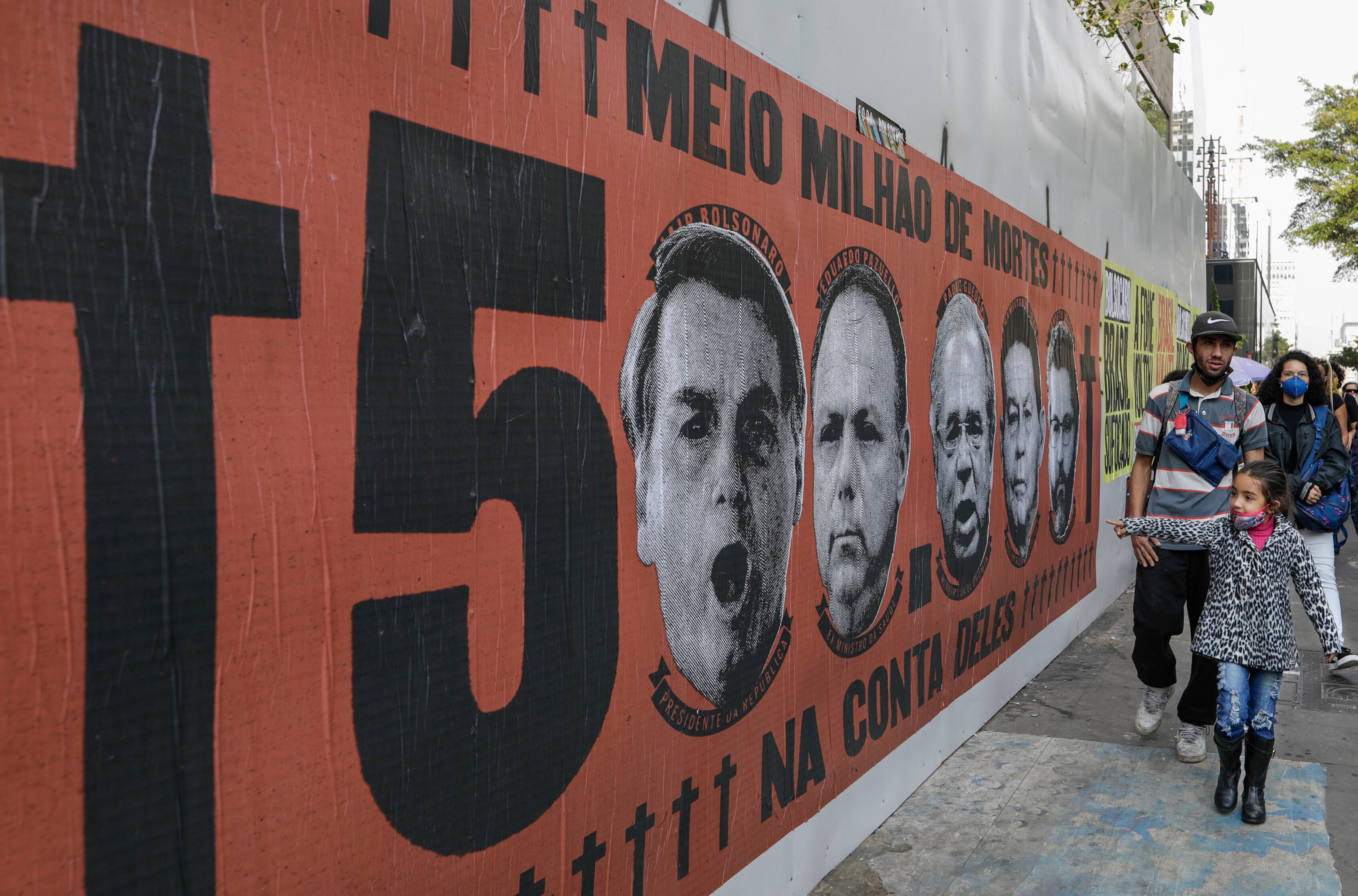 Una niña señala un mural con el rostro del presidente brasileño Jair Bolsonaro durante una protesta por su manejo de la pandemia del COVID-19 en la avenida Paulista, en Sao Paulo, Brasil. (AP Foto/Marcelo Chello)
