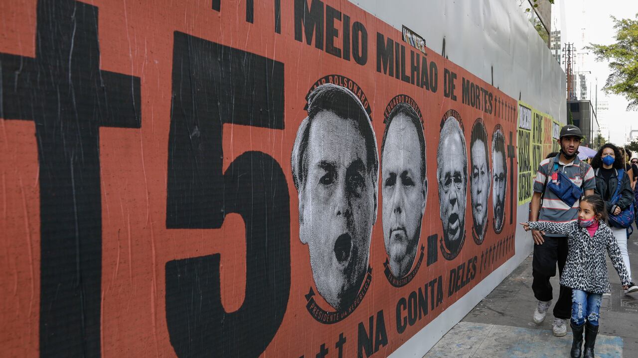 Una niña señala un mural con el rostro del presidente brasileño Jair Bolsonaro durante una protesta por su manejo de la pandemia del COVID-19 en la avenida Paulista, en Sao Paulo, Brasil. (AP Foto/Marcelo Chello)