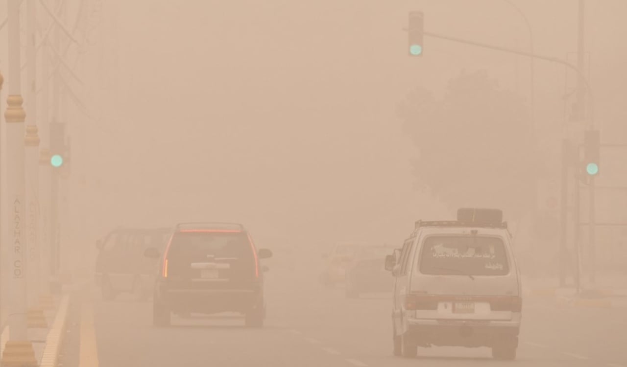 Poca visibilidad para los carros en las calles de la ciudad de Nasiriyah en Irak, por cuenta de la tormenta de arena