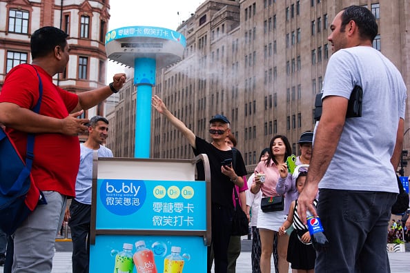 Personas se refrescan en Shanghai, China, ante la ola de calor.