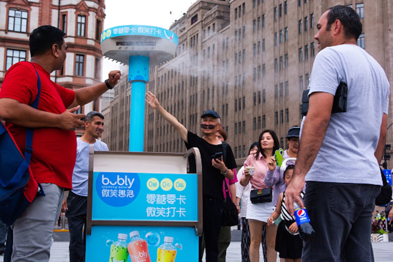 Personas se refrescan en Shanghai, China, ante la ola de calor.