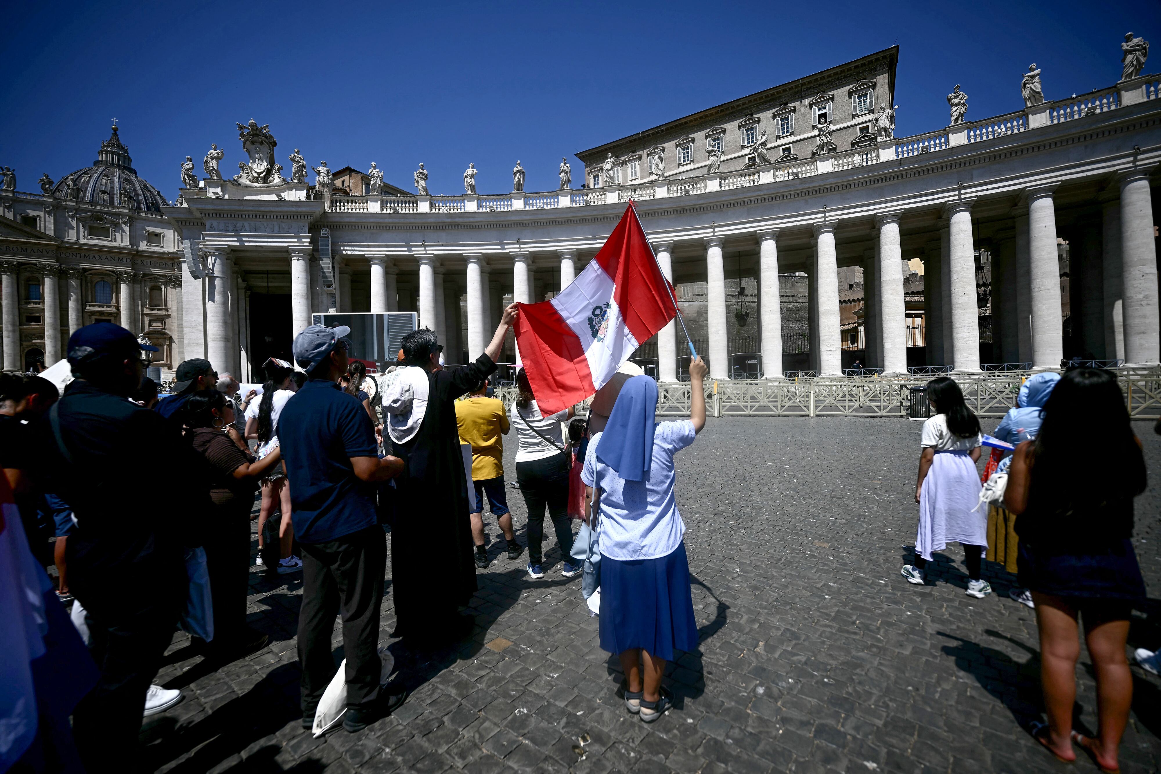 A nun waves a Peruvian national flag as she stands with fellow worshippers during Pope Leo XIV Angelus prayer on St. Peter's Square at The Vatican on August 9, 2026. (Photo by Filippo MONTEFORTE / AFP)