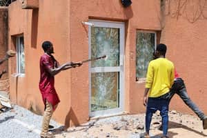 Pro-junta demonstrators break down one of the doors of the French embassy building before being dispersed by Nigerien security forces in Niamey, the capital city of Niger July 30, 2023. REUTERS/Souleymane Ag Anara REFILE – CORRECTING NATIONALITY NO RESALES. NO ARCHIVES