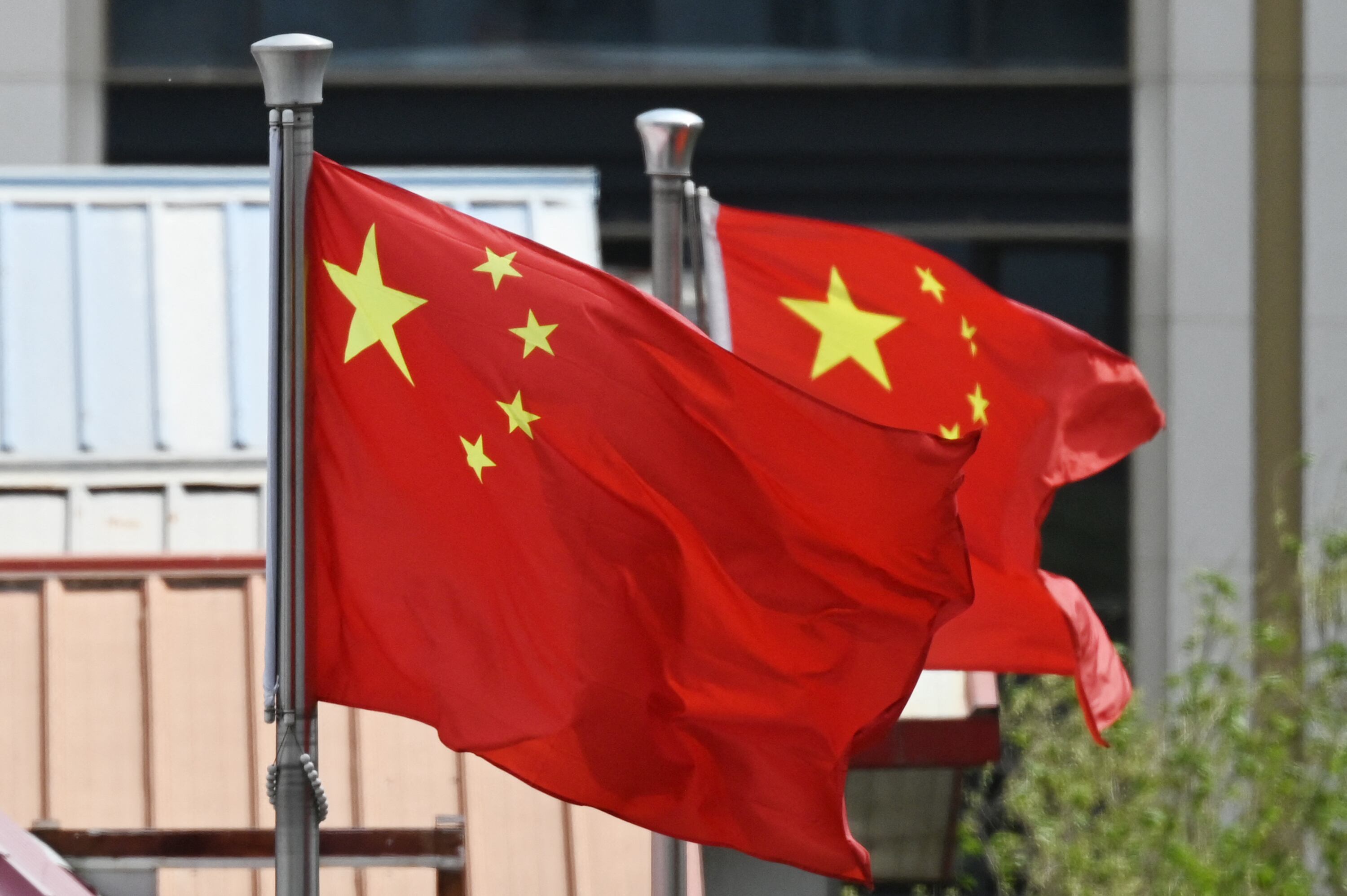 Chinese flags fly above apartment buildings in Beijing on April 12, 2025. China blasted President Donald Trump's tariffs on April 11 as a "numbers game" that "will become a joke", as Beijing raised reciprocal levies on US imports to 125 percent and said it would go no further. (Photo by GREG BAKER / AFP)
