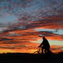Un hombre maneja en bicicleta durante una puesta de sol en Friburgo, Alemania. (AP)
