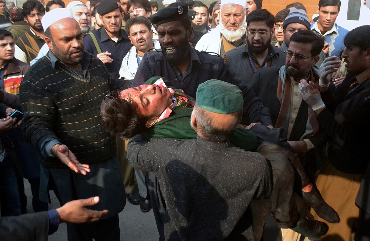 Guardias de seguridad de un hospital cargan uno de los estudiantes heridos durante el ataque talibán a una escuela en Peshawar, Pakistán. (AP)