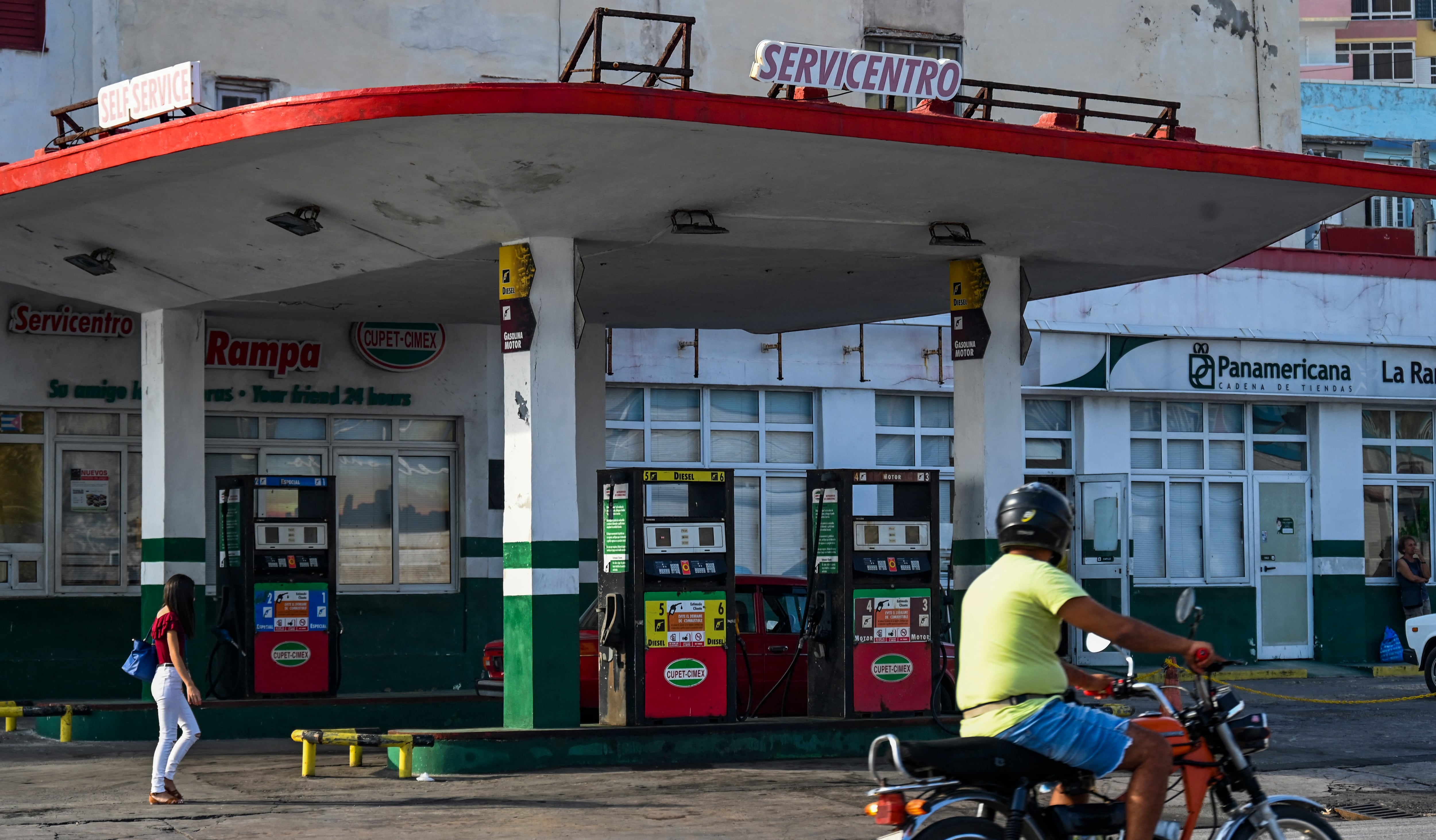 Un hombre en motocicleta pasa frente a una gasolinera vacía en La Habana el 24 de abril de 2023. - "¡Esto es un infierno!" exclama Lázaro Díaz, un mensajero cubano de 59 años que hace cola desde hace un día con la esperanza de conseguir gasolina, en la crisis de escasez de combustible más larga que los habaneros dicen haber vivido en años. (Foto de YAMIL LAGE / AFP)
