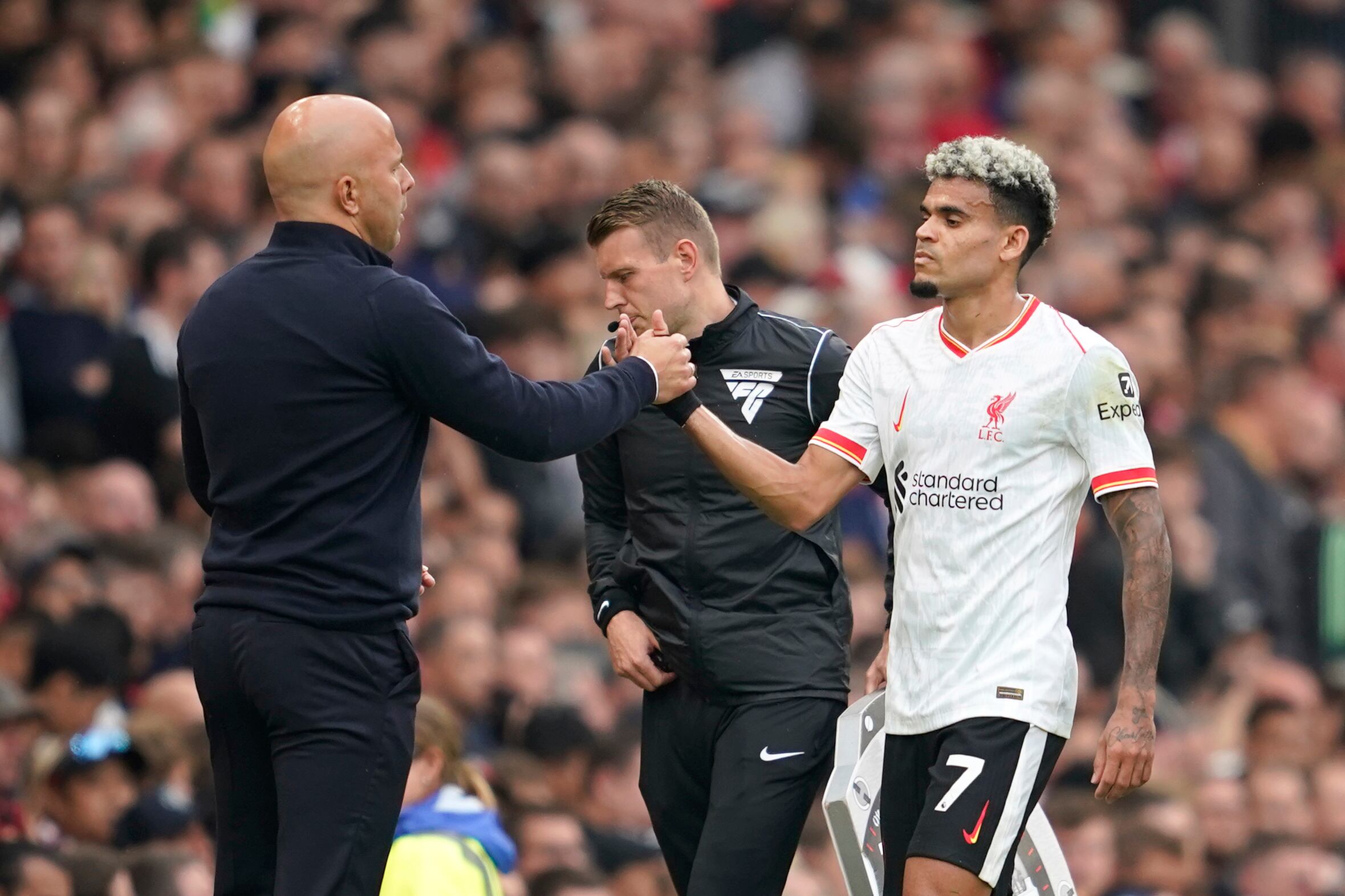 Liverpool's Luis Diaz, right, shakes hands with Liverpool's manager Arne Slot during the English Premier League soccer match between Manchester United and Liverpool at Old Trafford, Sunday, Sept. 1, 2024, in Manchester, England. (AP Photo/Dave Thompson)