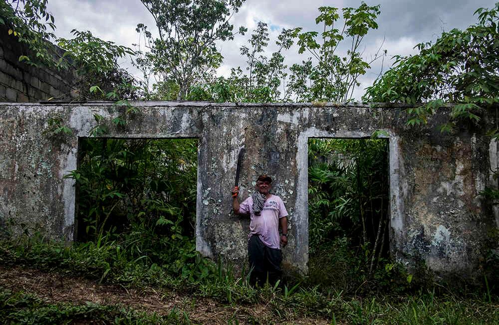 José Oswaldo Patiño de 56 años, posa en lo que alguna vez fue su casa. Allí vivió 25 años. El primer piso tenía dos locales donde vendían abarrotes y queso. Había 4 habitaciones en arriendo. En la segunda planta funcionaba una residencia con 27 piezas. José ahora vive jornaleando en la frontera de Colombia y Ecuador, mientras su esposa se quedó en Cartagena del Chairá.