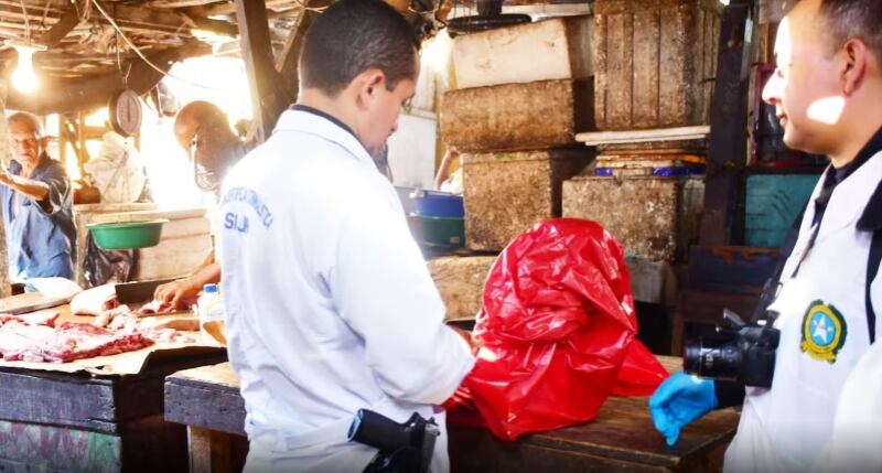 Autoridades verificando recipientes donde estaba el licor adulterado.