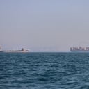 Un buque portacontenedores (a la derecha) y otro barco de carga pueden apreciarse en el estrecho de Ormuz, frente a Bandar Abbas, Irán.