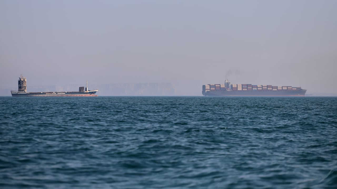 Un buque portacontenedores (a la derecha) y otro barco de carga pueden apreciarse en el estrecho de Ormuz, frente a Bandar Abbas, Irán.