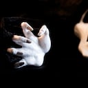 a white hand with screaming skull in background