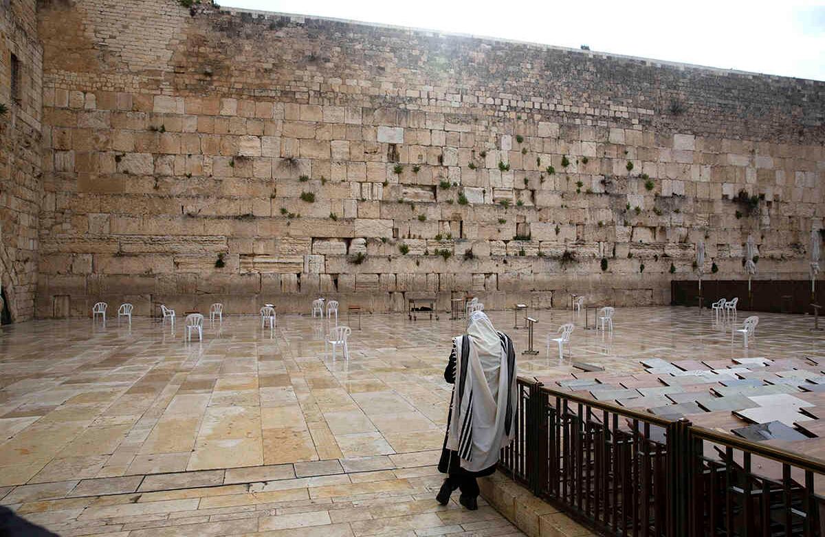Un hombre judío reza en el Muro de los Lamentos, el lugar más sagrado donde los judíos pueden rezar en la ciudad vieja de Jerusalén, el viernes 10 de abril de 2020.  AP Photo/Sebastian Scheiner