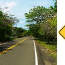 La reducción simétrica de la calzada es una señal preventiva utilizada en zonas donde la vía se estrecha o disminuye el número de carriles.