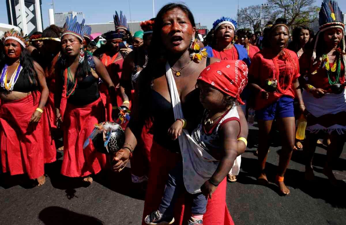 Una madre indígena que carga a su hijo participa en la Marcha de las mujeres indígenas, en Brasilia, Brasil, el 13 de agosto de 2019. Cientos de mujeres indígenas llegaron a la capital de Brasil para protestar por las políticas del presidente Jair Bolsonaro. (Foto AP / Eraldo Peres)