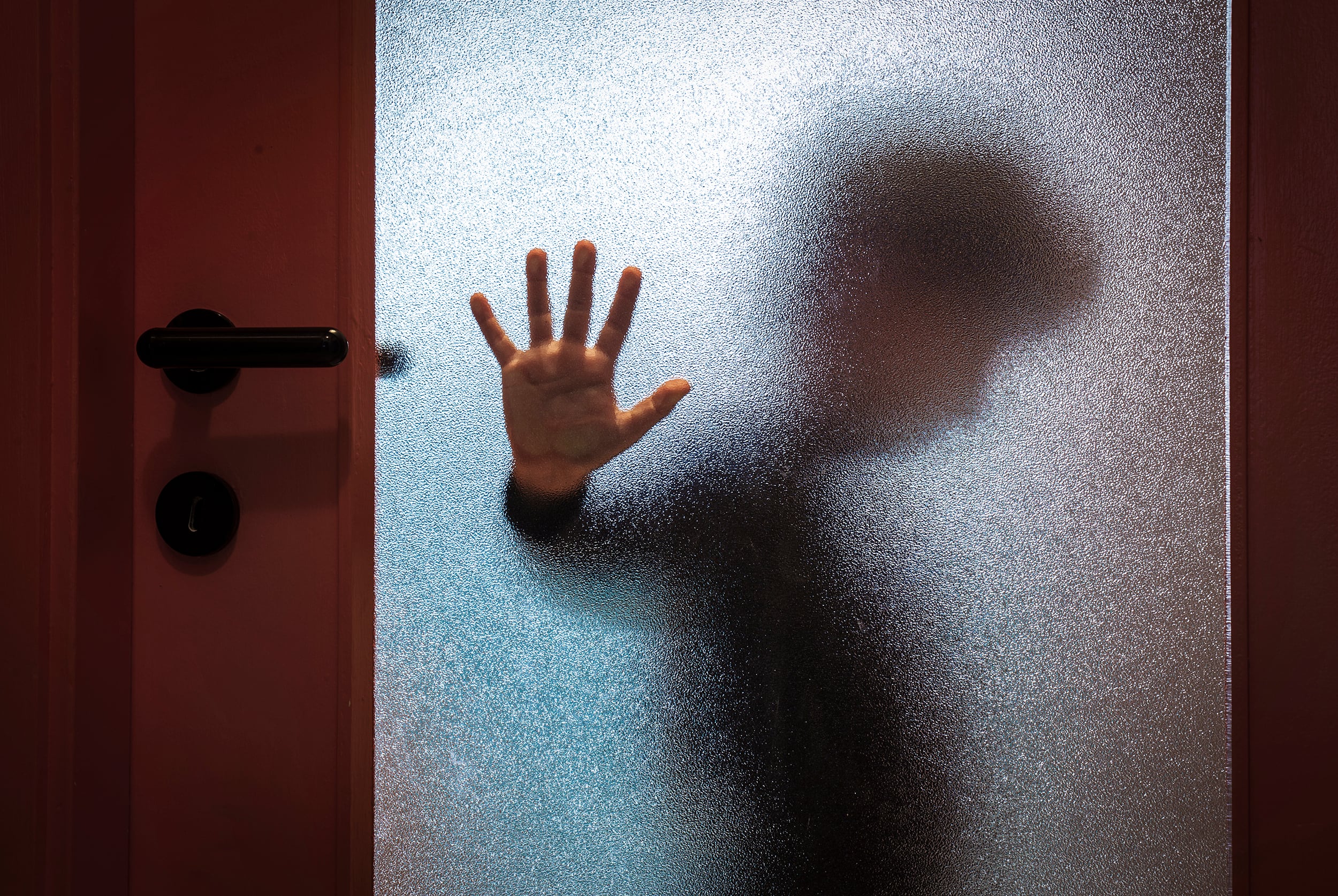 Niño detrás de la puerta de cristal