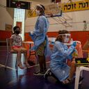 Personal médico prueba a niños israelíes sobre el coronavirus en una cancha de baloncesto convertida en un centro de pruebas de coronavirus, en Binyamina, Israel, el martes 29 de junio de 2021. El primer ministro de Israel está instando a los jóvenes del país a vacunarse a medida que el número de casos de coronavirus ha aumentado en los últimos días debido a un brote localizado de la variante Delta. Foto: AP / Ariel Schalit.