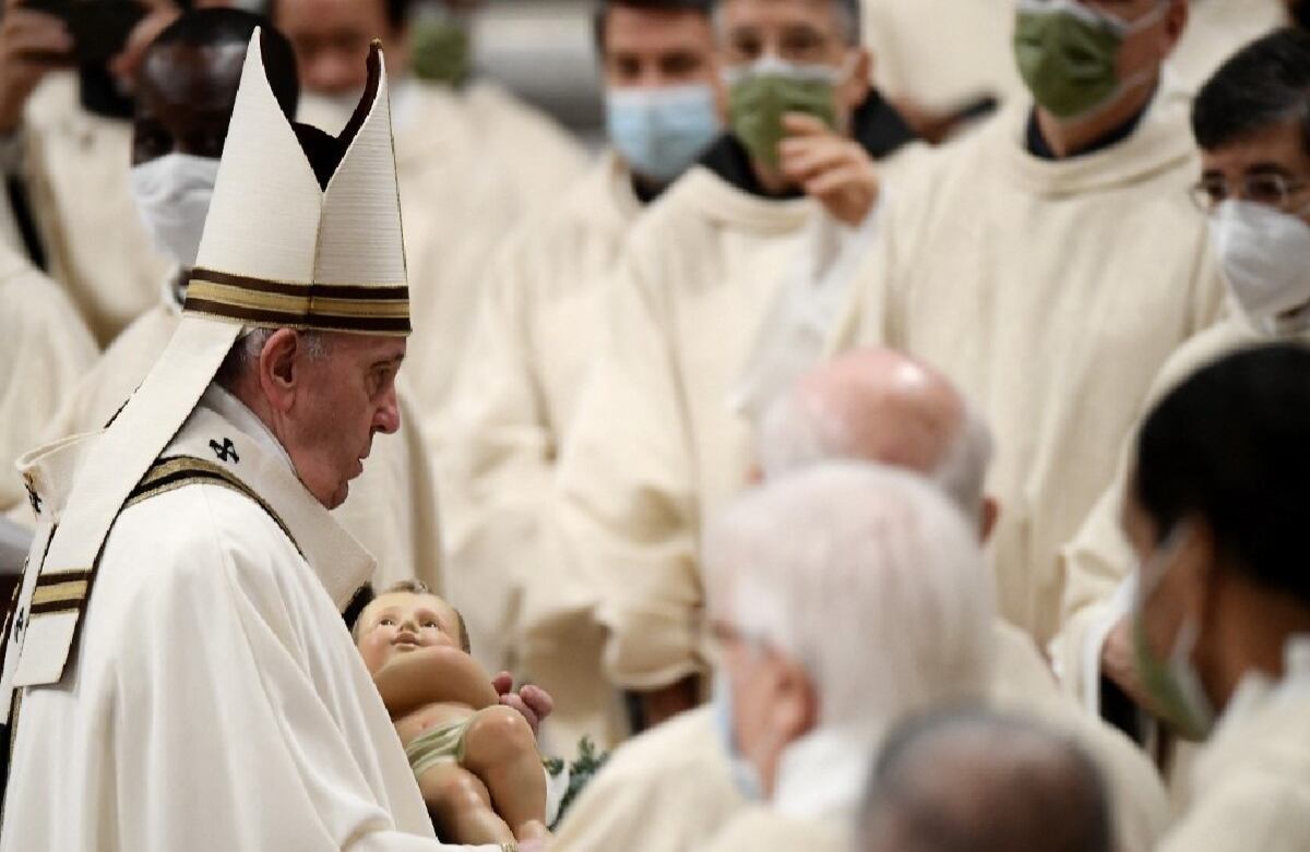 El Papa Francisco sostiene una figura del niño Jesús durante la misa de Nochebuena en la basílica de San Pedro en el Vaticano.