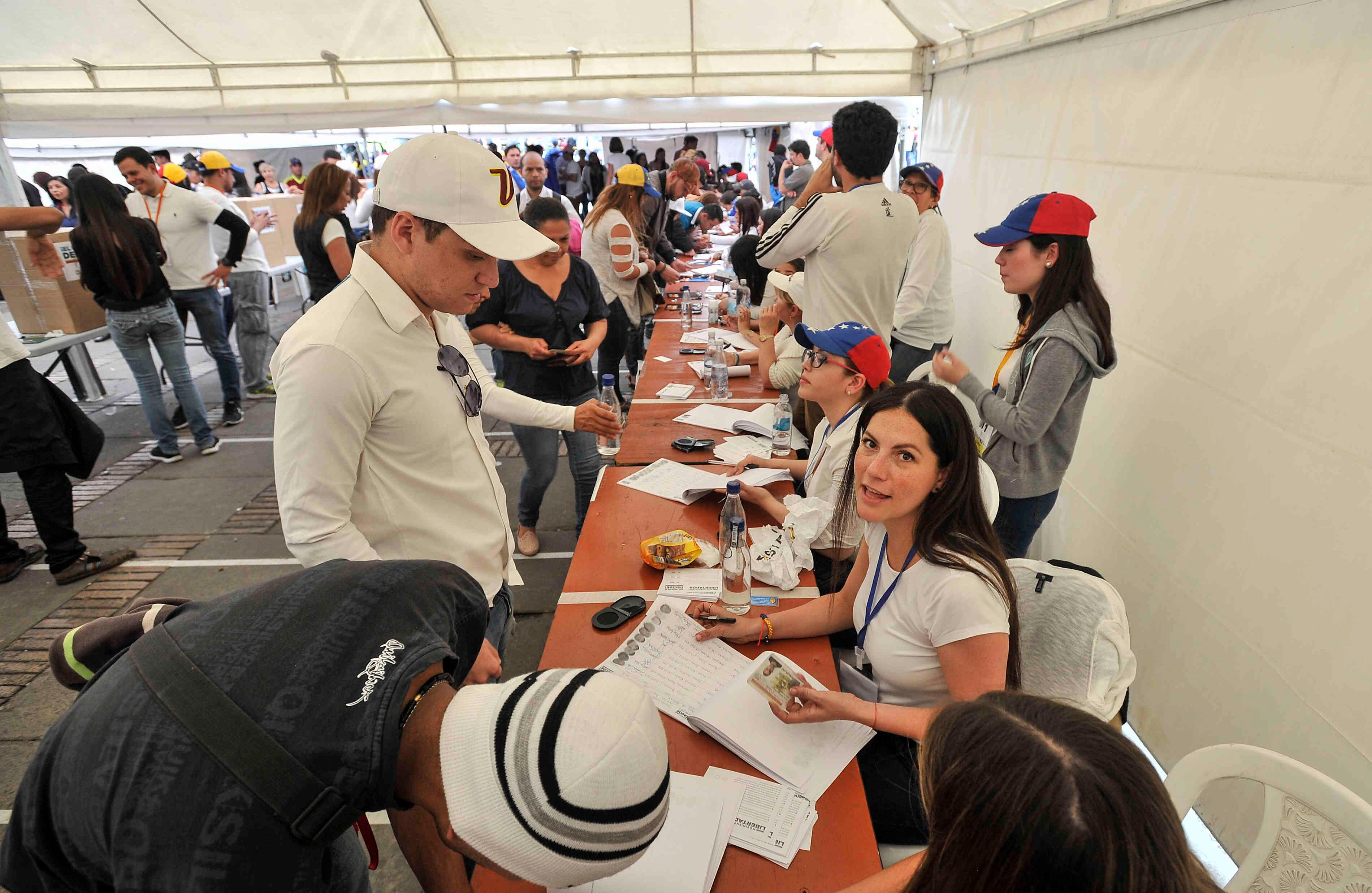 Ciudadanos venezolanos —residentes en Bogotá— acuden a las urnas ubicadas en la Plaza de Bolívar, en Bogotá,  el domingo 16 de julio de 2017, en Colombia, durante las votaciones al plebiscito. Esta jornada democrática ha sido  impulsada  por la oposición al gobierno de Nicolás Maduro. En las tarjetas, los ciudadanos deben responder ‘sí’ o ‘no’ a tres preguntas: la primera es si respalda el plan del presidente Nicolás Maduro de cambiar la Constitución; la segunda es si  apoya la intervención de las Fuerzas Armadas para “restituir el orden constitucional” y por último si desea un gobierno de unidad nacional. Foto: Carlos Julio Martínez / SEMANA