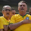 El ex presidente brasileño Jair Bolsonaro (C) canta el himno nacional junto a su esposa Michelle Bolsonaro (R) y el pastor Silas Malafaia (L) durante una manifestación en Sao Paulo, Brasil, el 25 de febrero de 2024.
