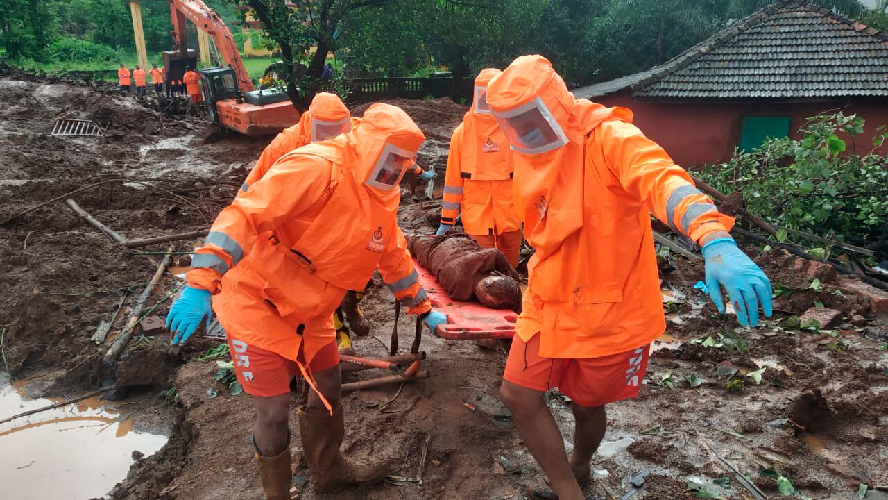 This photograph provided by India's National Disaster Response Force (NDRF) shows NDRF personnel recovering the body of a landslide victim at Ratnagiri in the western Indian state of Maharashtra, Sunday, July 25, 2021. Officials say landslides and flooding triggered by heavy monsoon rain have killed more than 100 people in western India. (National Disaster Response Force via AP)