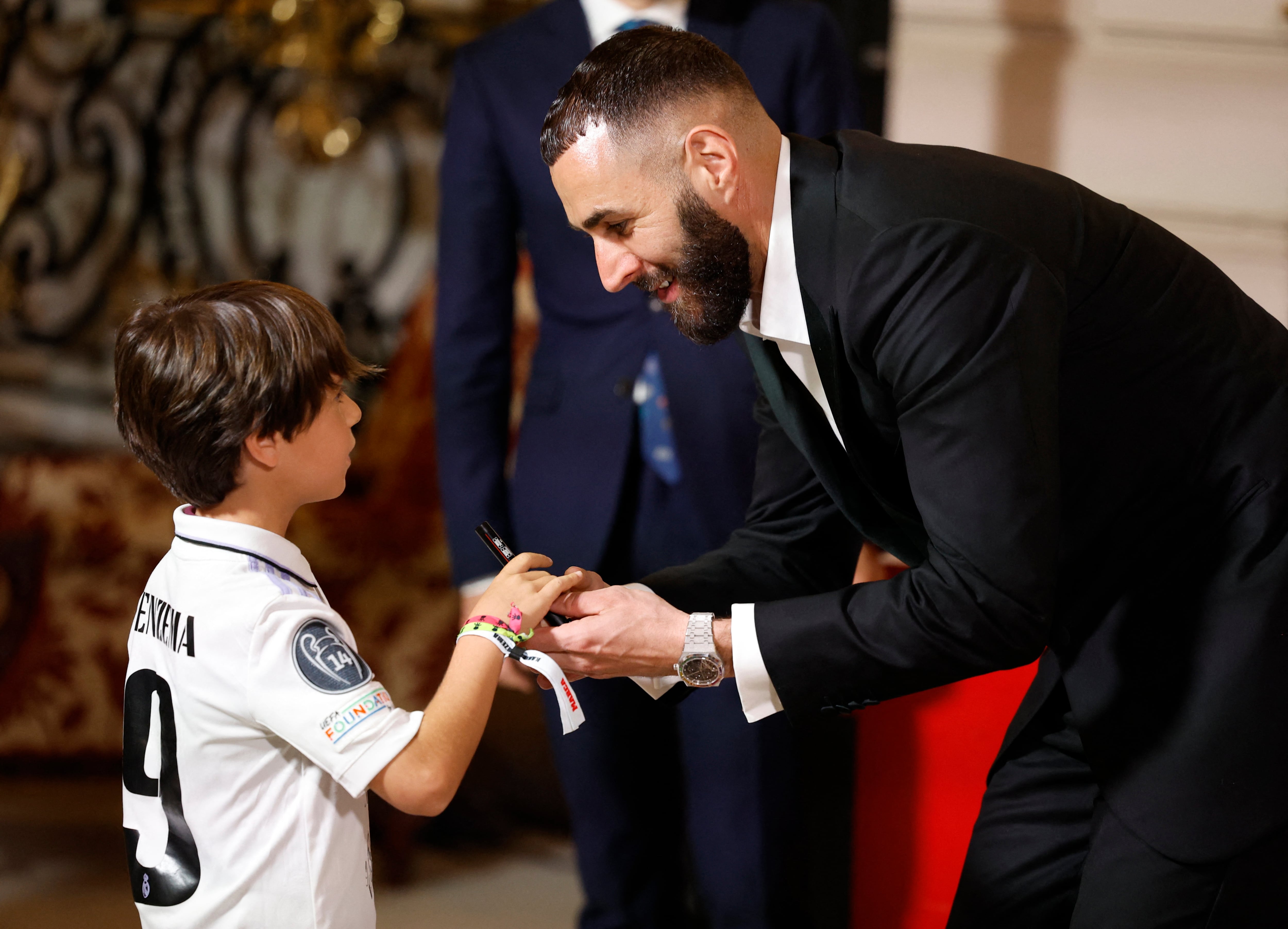 Soccer Football - Real Madrid's Karim Benzema receives the Marca Legend Award - Casino de Madrid, Madrid, Spain - June 1, 2023 Real Madrid's Karim Benzema with a young fan during the award ceremony REUTERS/Juan Medina