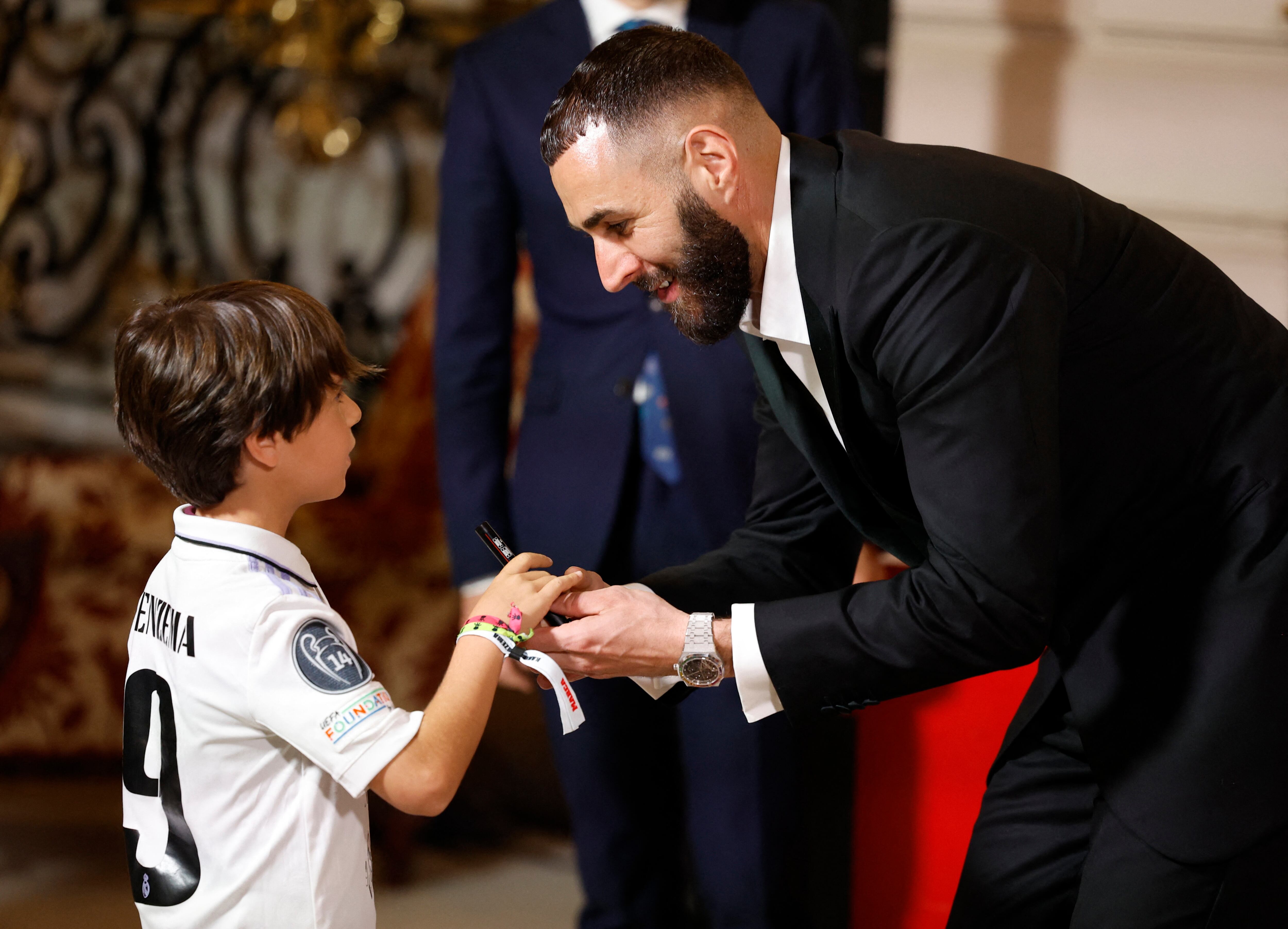 Soccer Football - Real Madrid's Karim Benzema receives the Marca Legend Award - Casino de Madrid, Madrid, Spain - June 1, 2023 Real Madrid's Karim Benzema with a young fan during the award ceremony REUTERS/Juan Medina