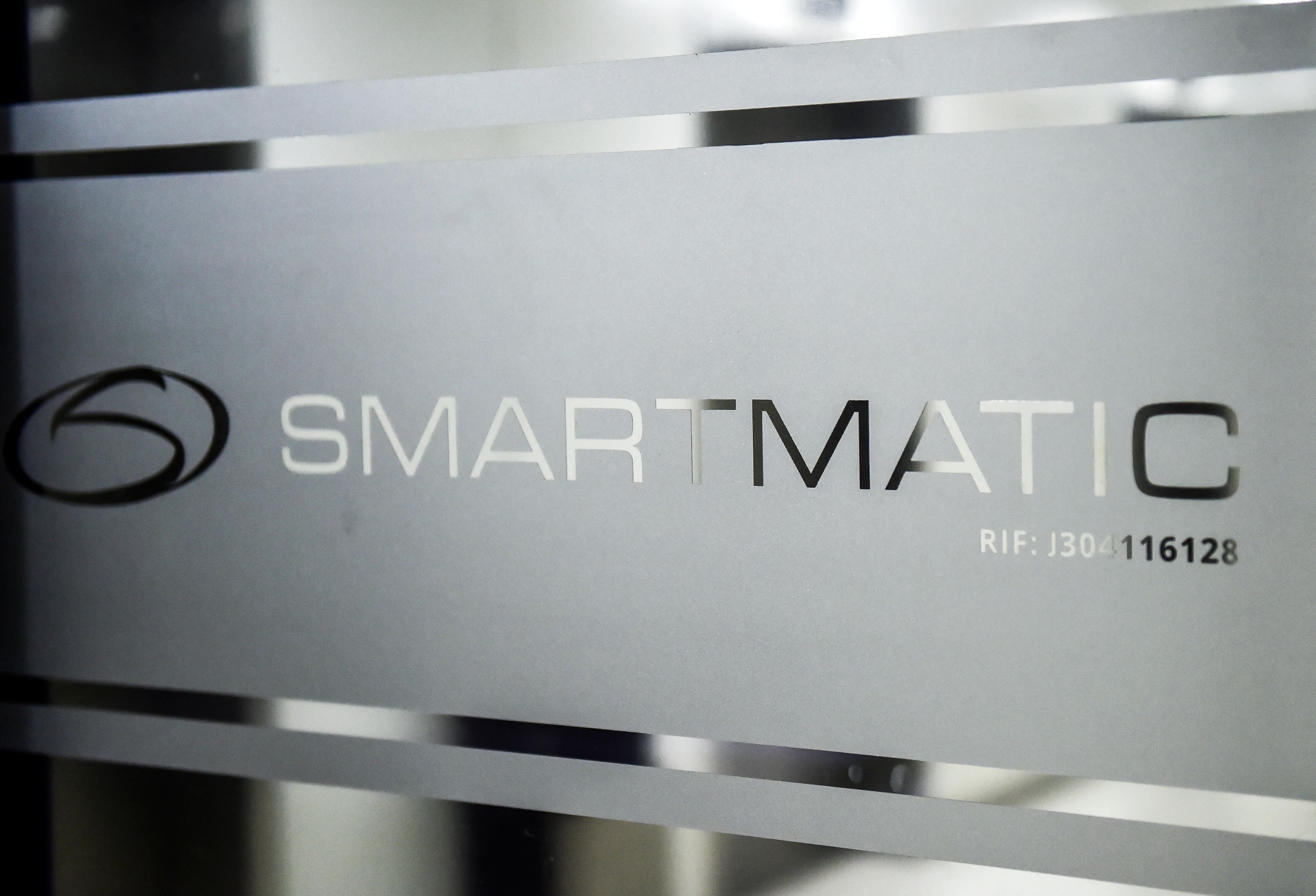 Imagen del logotipo de Smartmatic, la empresa proveedora de tecnología electoral venezolana, en una puerta corrediza de su sede en Caracas, el 2 de agosto de 2017