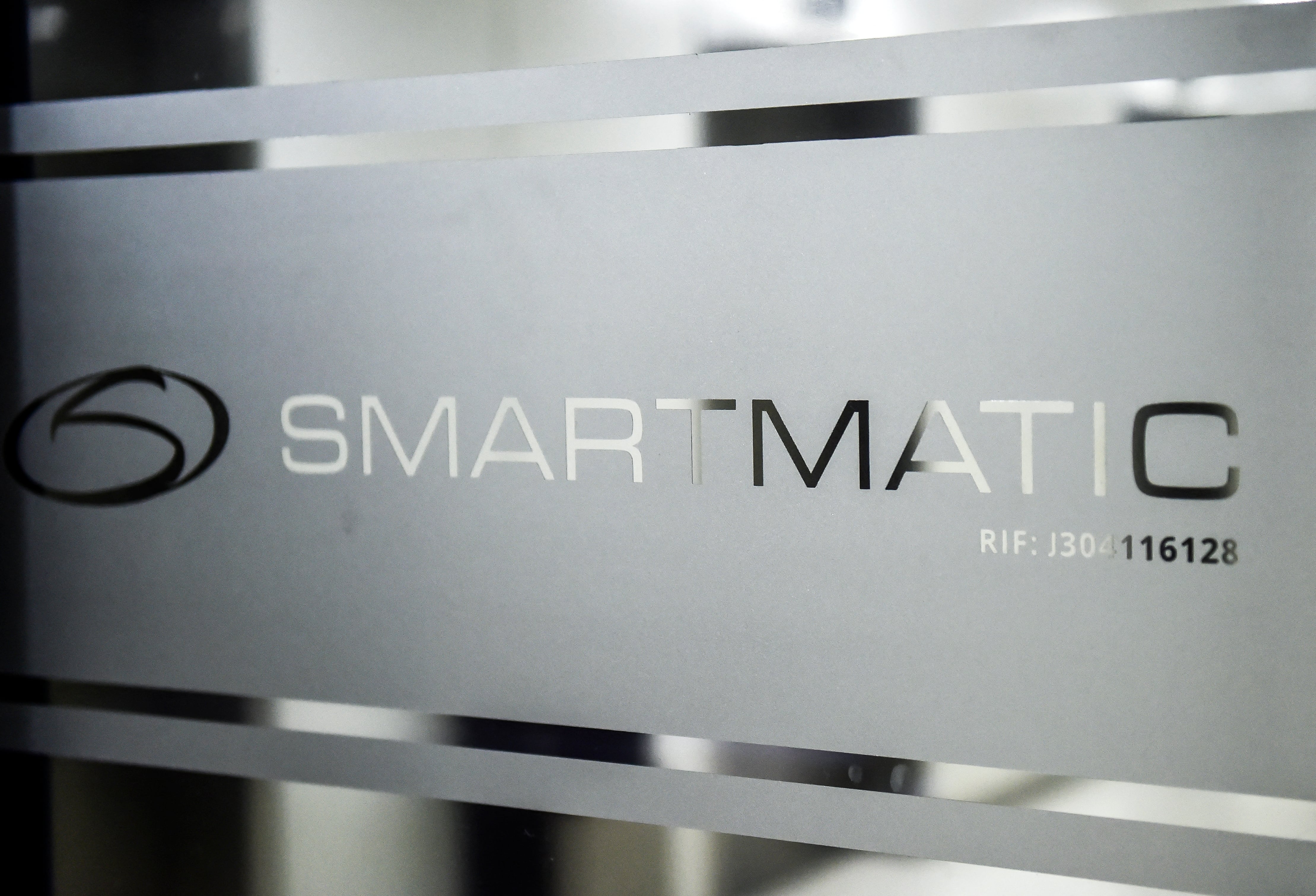 Imagen del logotipo de Smartmatic, la empresa proveedora de tecnología electoral venezolana, en una puerta corrediza de su sede en Caracas, el 2 de agosto de 2017