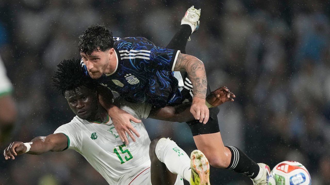 Marcos Senesi, de Argentina, y Pape Ndiaga Yade, de Mauritania, luchan por el balón durante un partido amistoso de fútbol en Buenos Aires, Argentina.