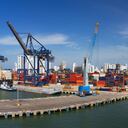 Vista panorámica de una actividad portuaria con cargueros, grúas y contenedores en el muelle del Puerto de Cartagena, Colombia.