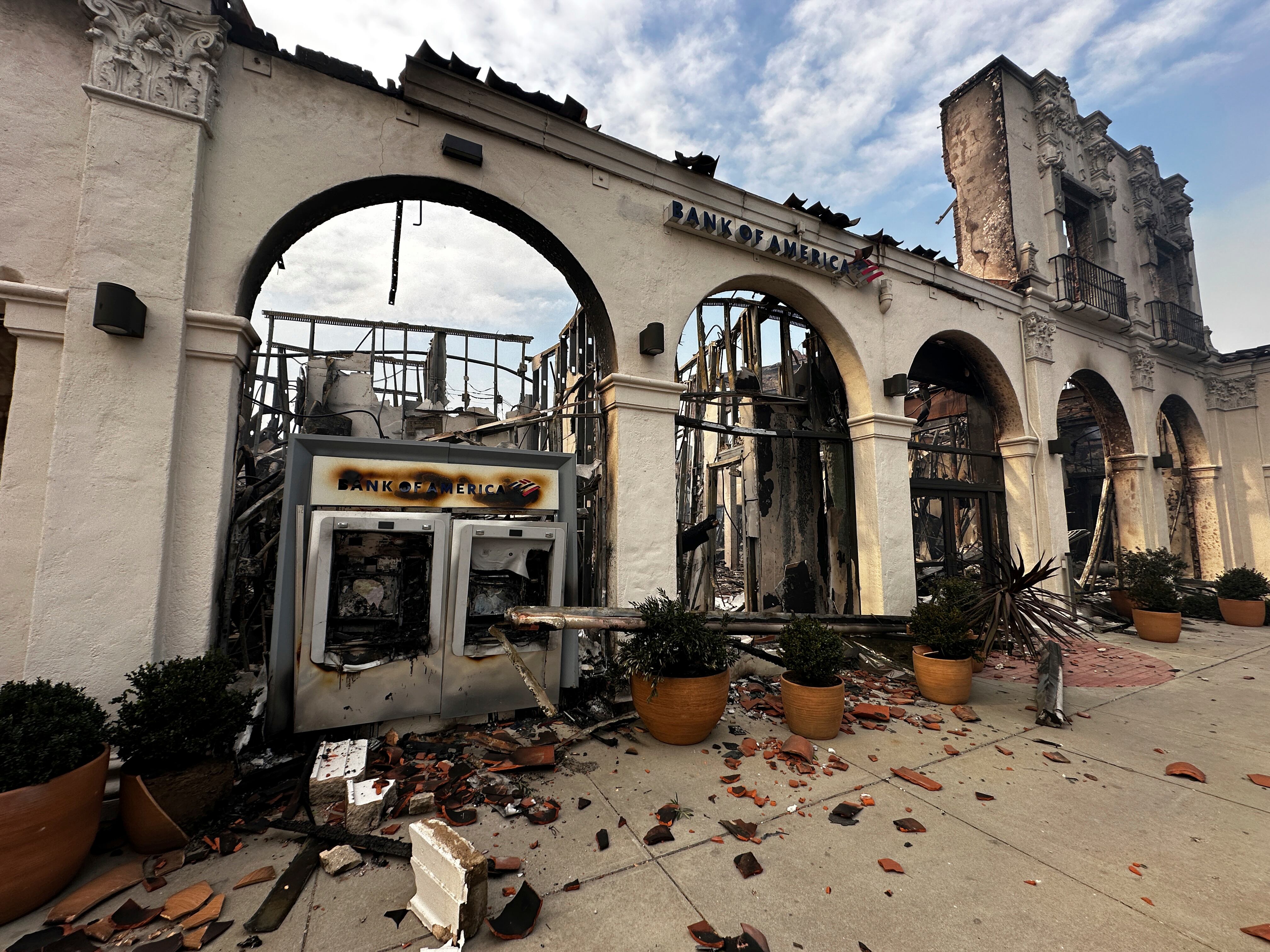 A fire-damaged Bank of America branch is seen after the Palisades Fire swept though in the Pacific Palisades neighborhood of Los Angeles, Wednesday, Jan. 8, 2025. (AP Photo/Eugene Garcia)