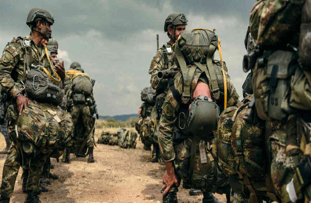 Un paracaidista militar se toma un instante para estirarse y balancear el peso de su equipo mientras espera el siguiente salto. Foto: Oliver Ehmig