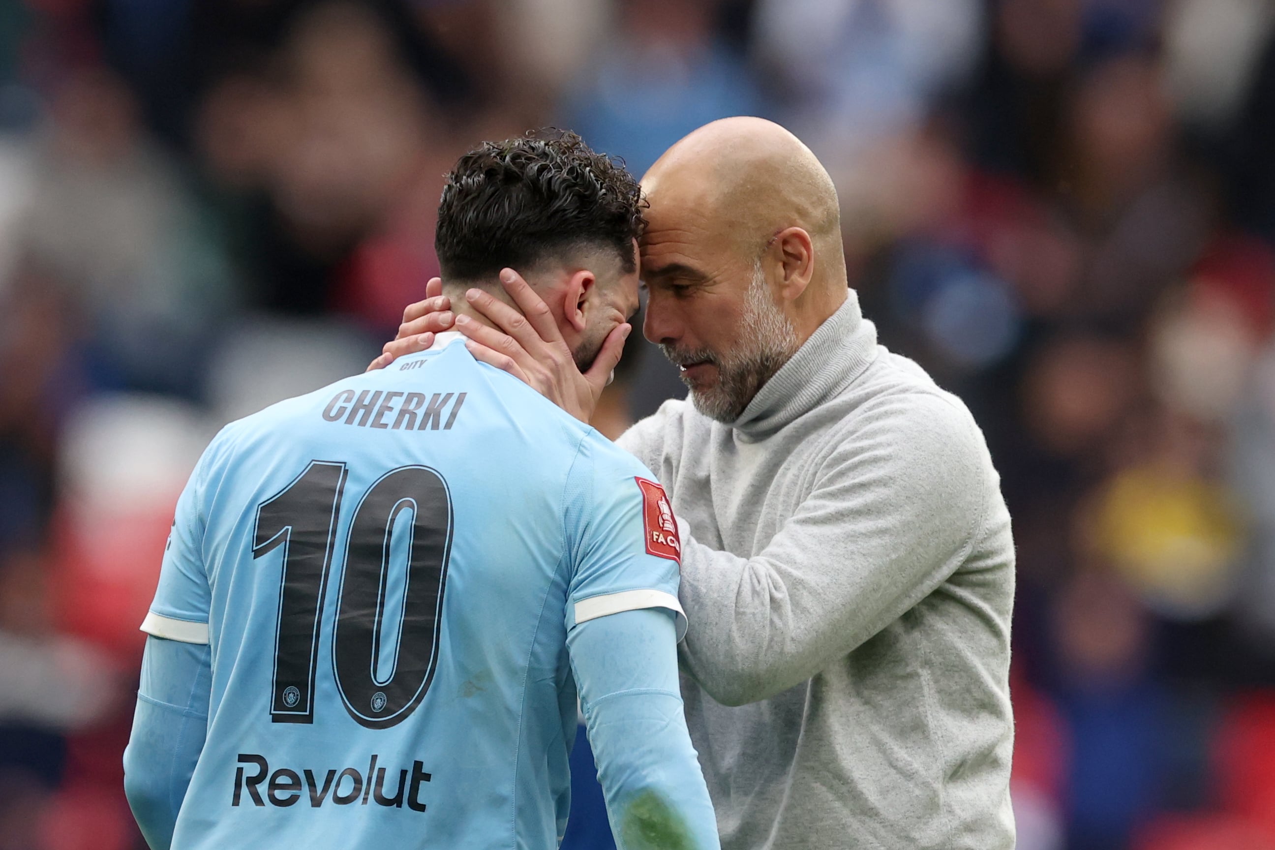 Manchester City's head coach Pep Guardiola, right, celebrates with Manchester City's Rayan Cherki after winning the English FA Cup final soccer match between Chelsea and Manchester City in London, Saturday, May 16, 2026. (AP Photo/Richard Pelham)