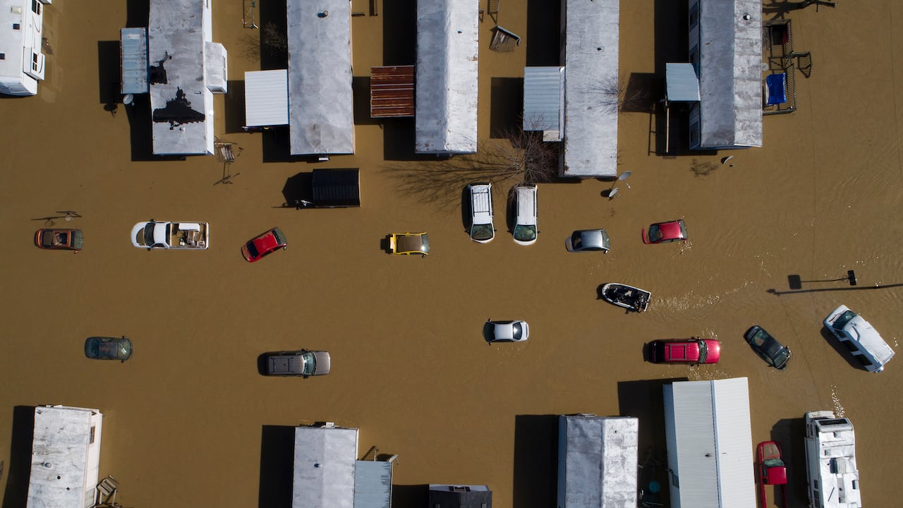 En esta foto tomada por un dron, un bote atraviesa autos y remolques parcialmente sumergidos en la ciudad de Beattyville, Kentucky, luego de las fuertes lluvias que causaron la inundación del río Kentucky, el martes 2 de marzo de 2021 (Alex Slitz / Lexington Herald). -Líder vía AP)
