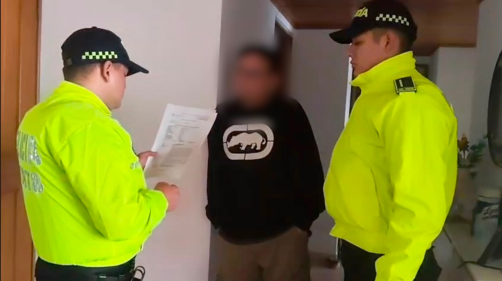 Policías de la Dijín lee derechos a uno de los capturados.