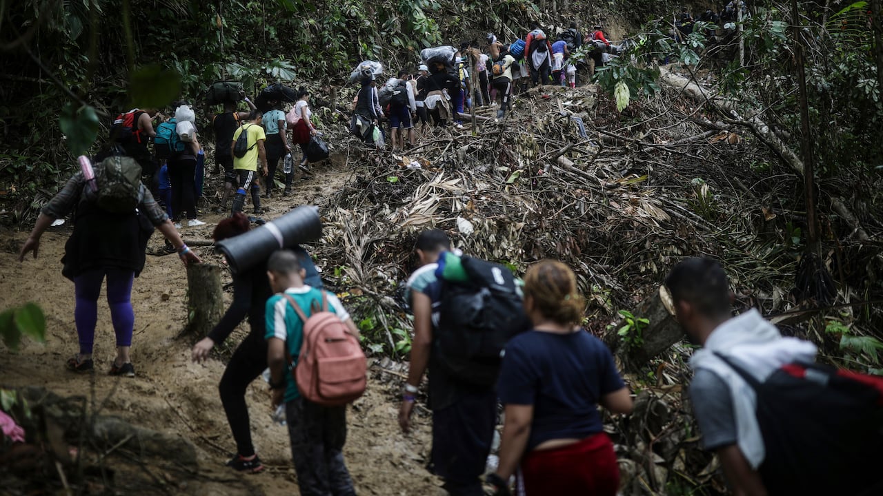 En esta imagen de archivo, migrantes cruzan a pie la selva del Darién desde Colombia a Panamá, con la esperanza de llegar a Estados Unidos, el 9 de mayo de 2023. El aumento de migrantes que van desde Colombia a Estados Unidos, a través de la selva del Darién hasta Panamá, alcanza una escala industrial que podría rondar las 500.000 personas este año. (AP Foto/Iván Valencia, archivo)