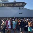 Los migrantes recién llegados esperan en el puerto de la isla siciliana de Lampedusa, Italia, el 27 de agosto de 2023.