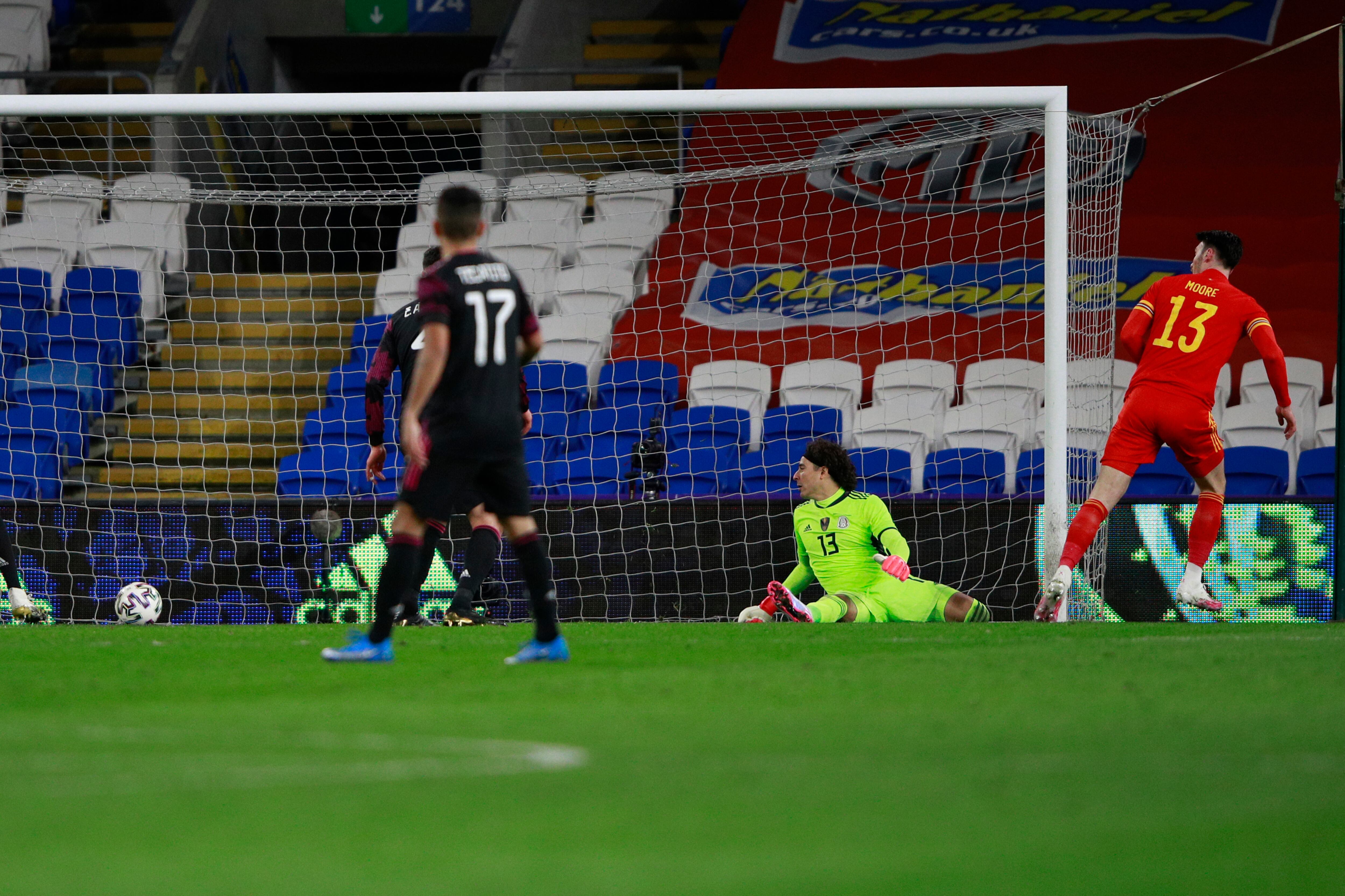 Kieffer Moore, de la selección de Gales, anota frente al arquero de México, Guillermo Ochoa, durante un partido amistoso realizado el sábado 27 de marzo de 2021, en Cardiff (AP Foto/Ian Walton)