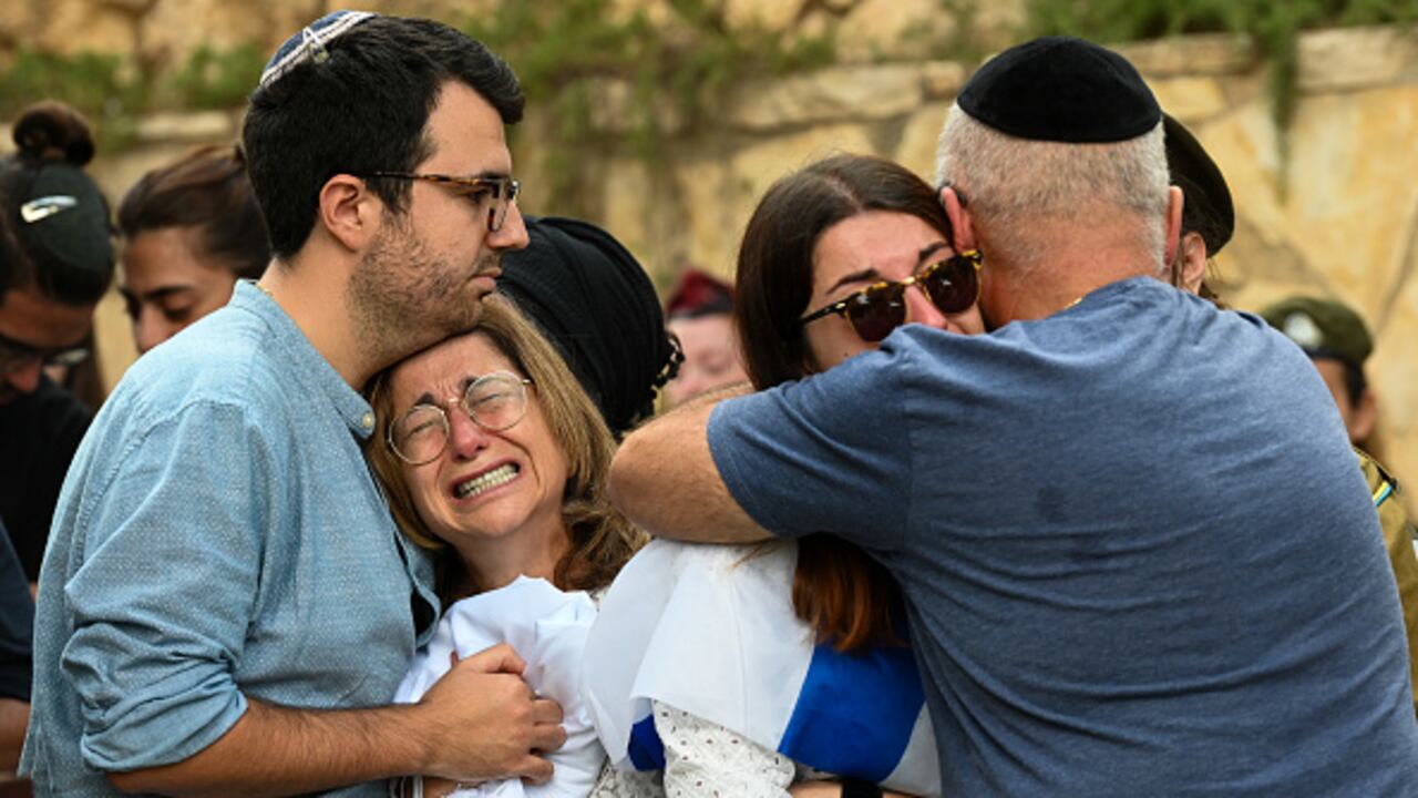 La madre y la familia inmediata de Valentin (Eli) Ghnassia, de 23 años, quien murió en una batalla con militantes de Hamas en el Kibbutz Be'eeri, cerca de la frontera israelí con la Franja de Gaza, lloran durante su funeral el 12 de octubre de 2023 en el cementerio militar Monte Herzl en Jerusalén, Israel. (Foto de Alexi J. Rosenfeld/Getty Images)